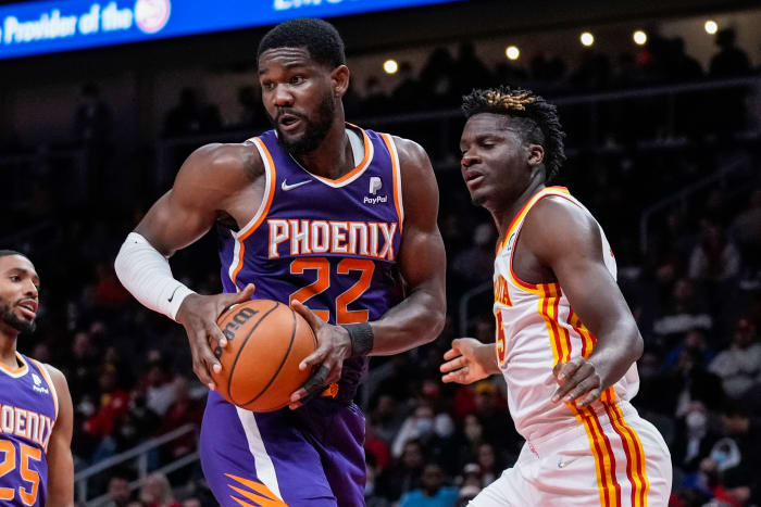 Deandre Ayton controls a rebound over Clint Capela.